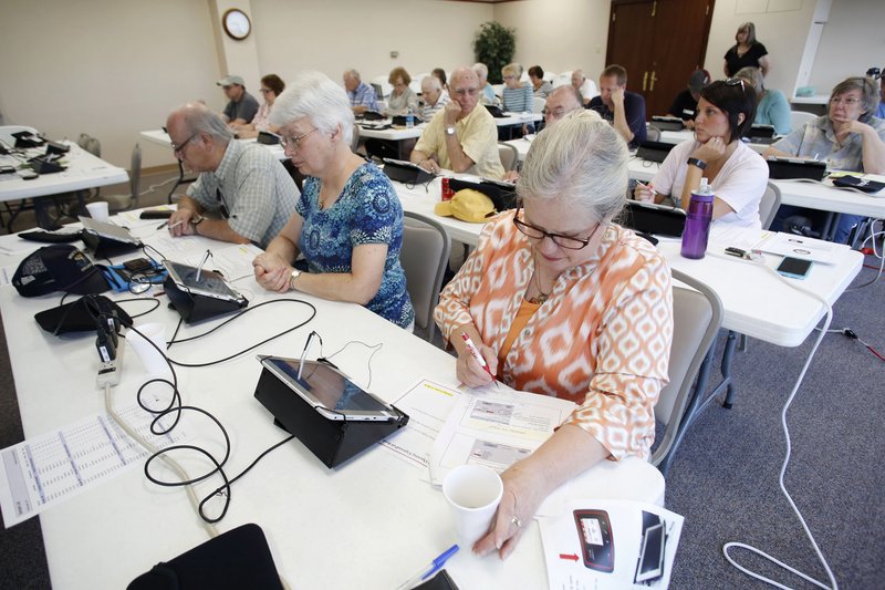 Jamie Snider (right), with the Mount Sequoyah polling center, reviews the ExpressPoll Book on Thursday during training by the Election Commission at the Washington County Courthouse in Fayetteville. The new ExpressPoll Book will help the checking in procedure. 