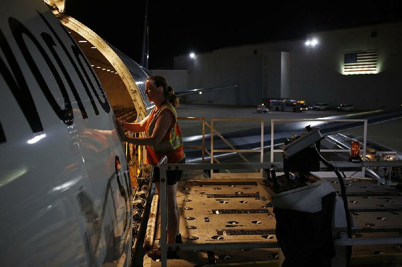 A worker finishes unloading a cargo jet at a UPS facility last week in Louisville, Ky. The shipping company had solid performances in its international and domestic package units in the second quarter. 