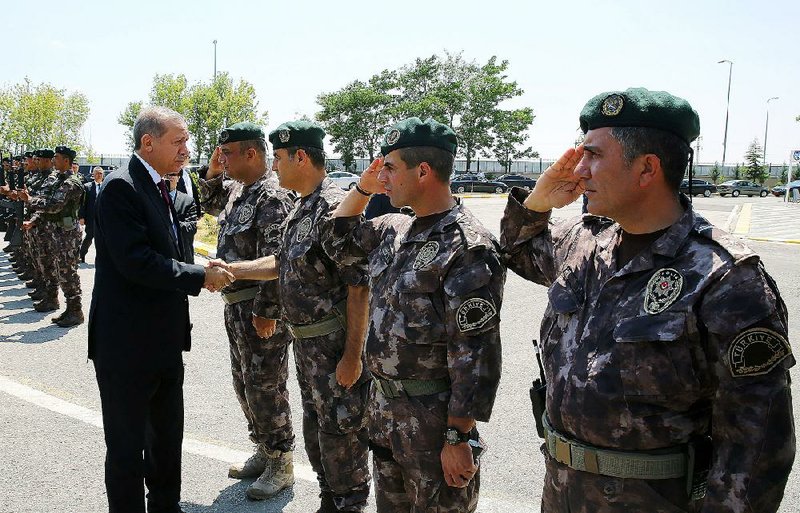 Turkey President Recep Tayyip Erdogan (left) visits Friday with officers of the police special forces at their headquarters in Ankara. 