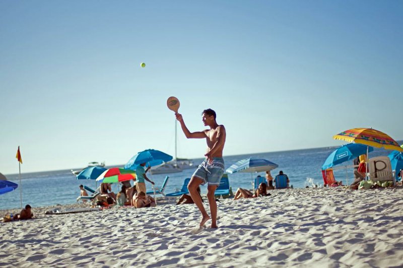 Visitors play beach tennis and enjoy the sun on Lagoon Beach in Cape Town, South Africa, in December. 