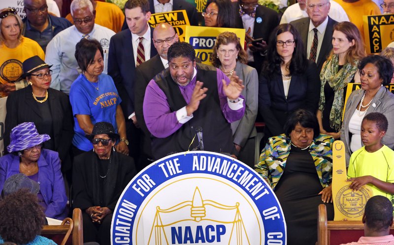 North Carolina NAACP president the Rev. William Barber (center) gestures June 21 during a news conference in Richmond, Va.