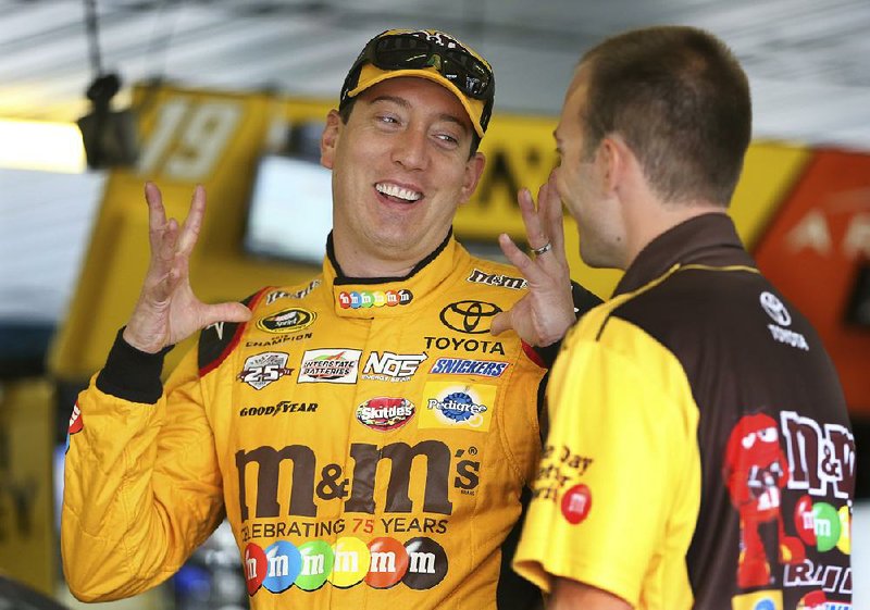 Kyle Busch (18) talks to a crew member in the garage area at Pocono Raceway during practice for Sunday's NASCAR Sprint Cup Series Pennsylvania 400 auto race Sunday Friday, July 29, 2016, in Long Pond, Pa. 