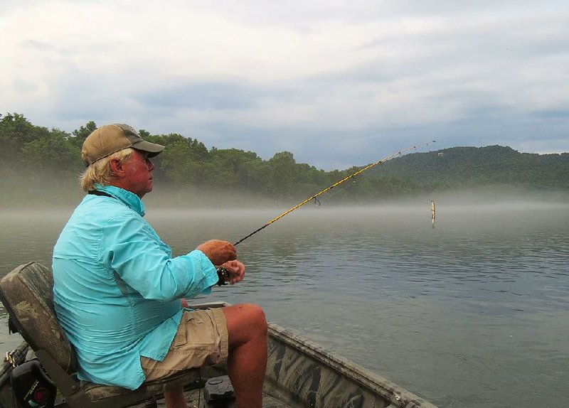 Ray Tucker savors the final moments of a fine day of fishing Tuesday as the fog envelops the White River near Mountain Home. 