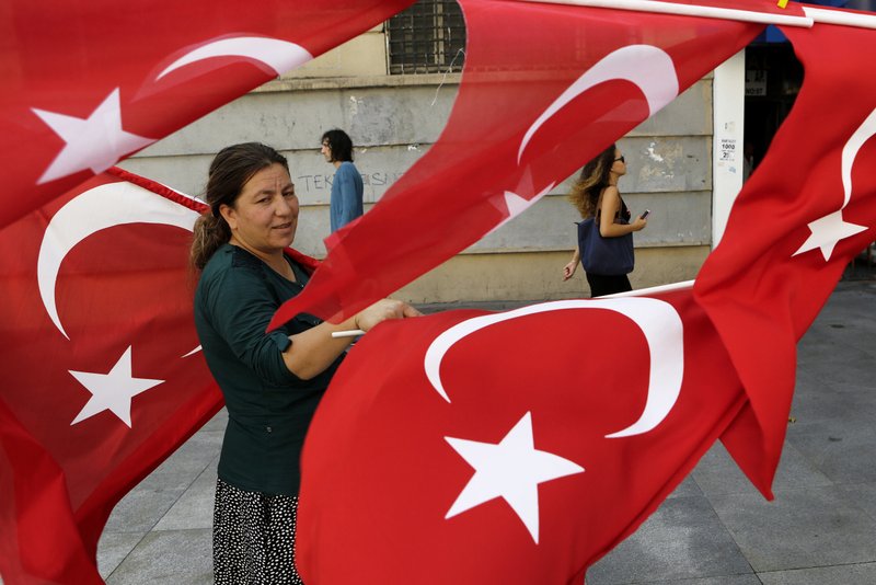 A woman sales Turkish flags in Istanbul, on Saturday, July 30, 2016. Turkey has demanded the United States extradite Fethullah Gulen, a cleric living in self-imposed exile in Pennsylvania whom it accuses of being behind the violent July 15 coup attempt that left more than 200 people dead. 