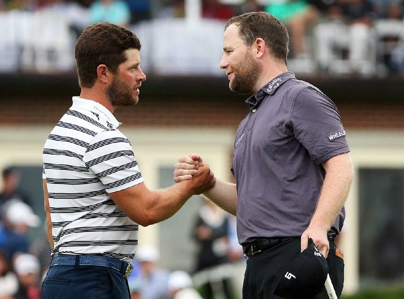 PGA Tour golfer David Lingmerth (Arkansas Razorbacks) shakes hands with playing partner Branden Grace (right) on the 18th green during the final round of the PGA Championship on Sunday at Baltusrol Golf Club in Springfield, N.J. Grace finished 9 under par in a tie for fourth and earned $405,000, five shots ahead of Lingmerth, who tied for 22nd and earned $75,636.