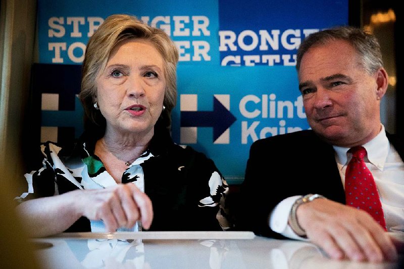 Hillary Clinton and running mate Tim Kaine speak on their campaign bus after visiting Imani Temple Ministries in Cleveland on Sunday. Clinton and Kaine are on a three-day bus tour.