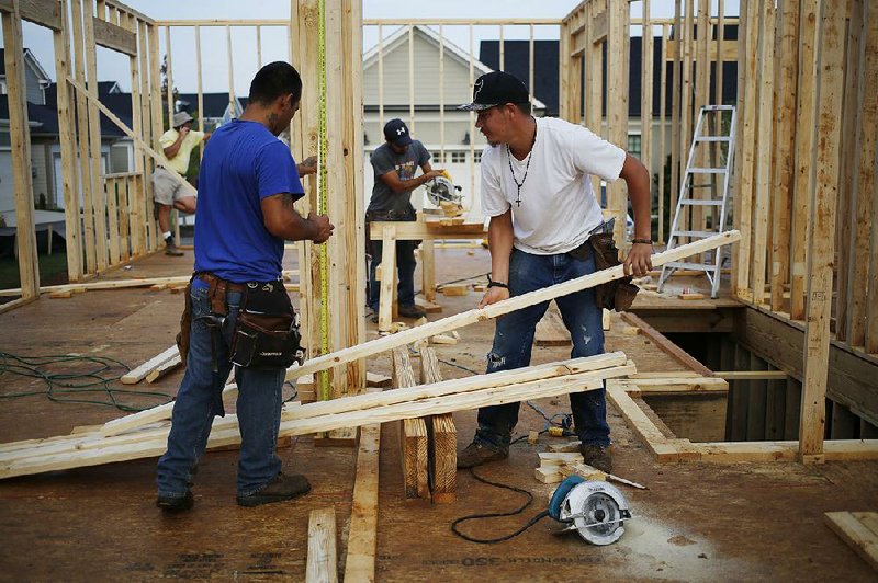 Framers work on a house being built in the Norton Commons subdivision of Louisville, Ky., on Friday. U.S. construction spending fell for a third-straight month in June, the Commerce Department reported Monday.