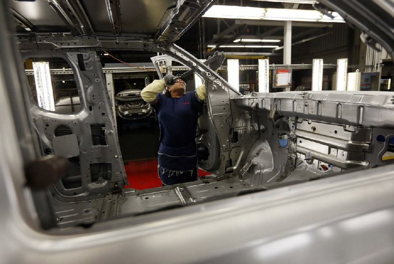 A technician files down imperfections on the door frame of a Titan truck in April on the assembly line at the Nissan Canton Vehicle Assembly Plant in Canton, Miss.