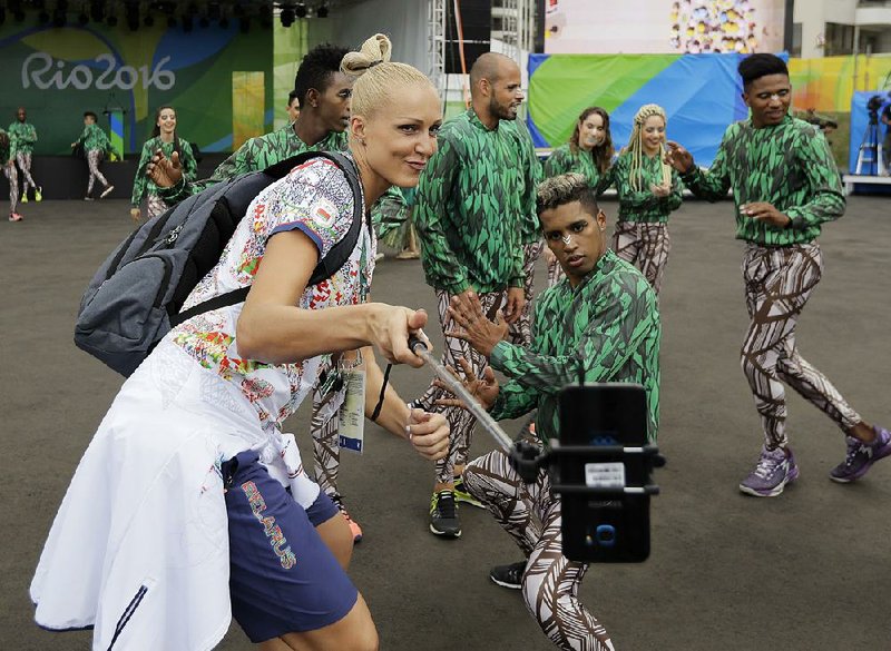 Yelena Leuchanka, a member of the Belarus women’s basketball team, takes a selfie with performers before a welcoming ceremony at the Olympic athletes village in Rio de Janeiro on Tuesday. The opening ceremony for the Games is Friday. 