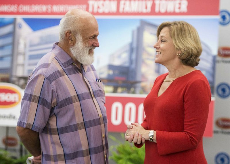 John Tyson, chairman of the board for Tyson Foods, talks Tuesday with Marcy Doderer, president and CEO of Arkansas Children’s Hospital, at the Tyson Foods headquarters in Springdale after announcing that the Tyson family and Tyson Foods donated $15 million to the hospital for its Northwest Arkansas campus. 