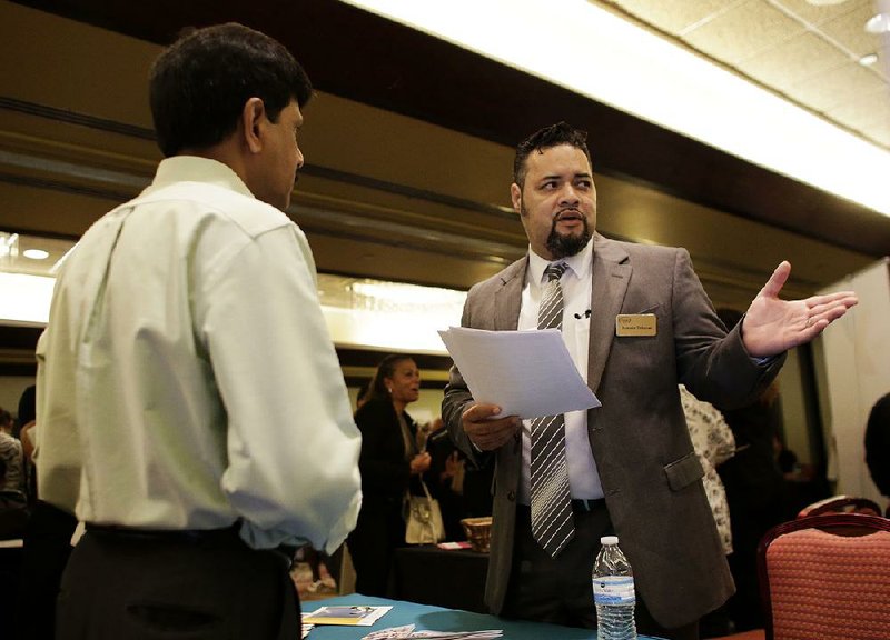 Ronnie Teheran with Service Corporation International (right) talks with a job applicant at a job fair in Miami Lakes, Fla., in July. U.S. companies added 179,000 jobs in July, according to a private survey, payroll processor ADP said Wednesday. 