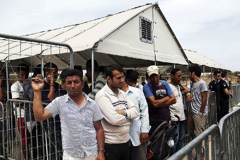 People photographed in June at a migrant camp in Athens were lining up to register for asylum in Greece. 
