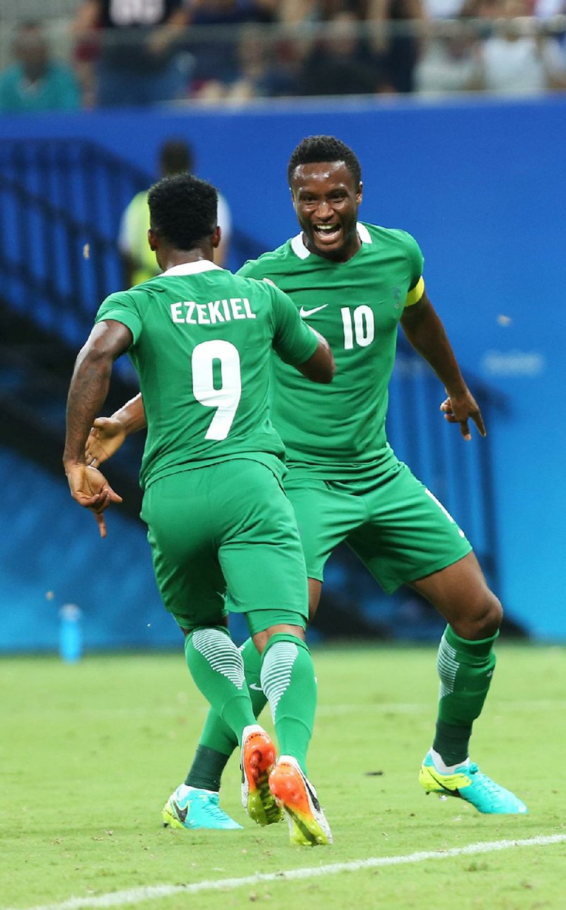 Nigeria’s Imoh Ezekiel (left) celebrates with teammate John Obi Mikel during Thursday’s match against Japan in
Manaus, Brazil. The Nigerians, who landed in Rio six hours before the game, won 5-4.
