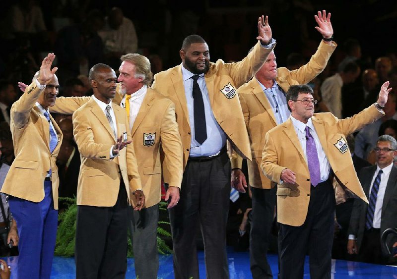 Members of the new Pro Football Hall of Fame class acknowledge the crowd at a dinner honoring the inductees after they received their gold jackets Thursday night. Shown are (from left) Tony Dungy, Marvin Harrison, Kevin Greene, Orlando Pace, Brett Favre and Eddie DeBartolo. Representatives for Dick Stanfel and Ken Stabler, the posthumous inductees, are not pictured.