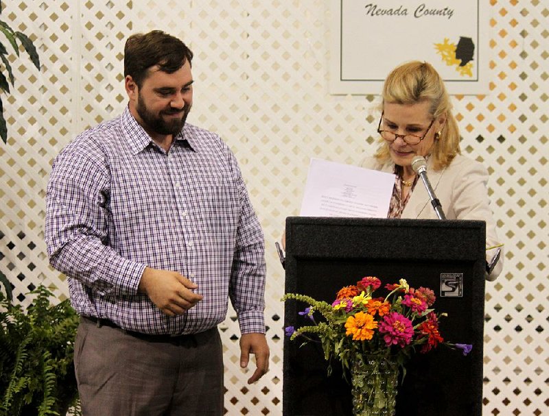 Jeremy Dickerson of Prescott (left) and Stacy Hurst, director of the Arkansas Department of Heritage, mark the transfer of ownership of 448 acres in Nevada County on Friday from a timber-management company to a nonprofit that will preserve and develop the Elkins Ferry Battlefield. 