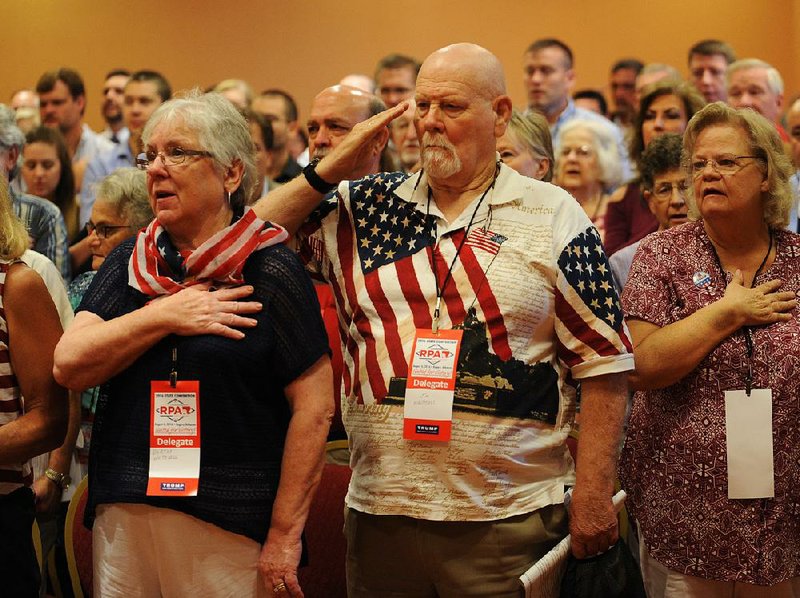 Bertha and Jim Whitesell of Mountain Home sing “The Star-Spangled Banner” with other delegates Saturday during the Republican Party of Arkansas convention in the John Q. Hammons Center in Rogers. 