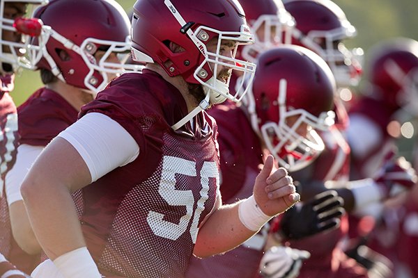 Arkansas offensive lineman Jake Raulerson (50) leads players during practice Thursday, Aug. 4, 2016, in Fayetteville. 