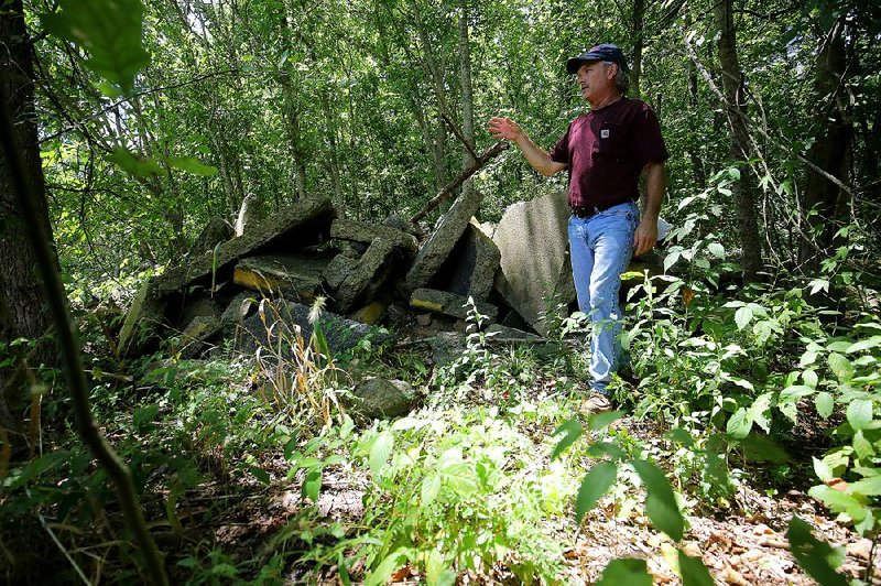 Paul Covert stands near concrete debris that he says are remains of a past Interstate 30 widening project. He contends the Arkansas Highway and Transportation Department is spending more than necessary to correct a flooding problem on the interstate near Crooked Creek.