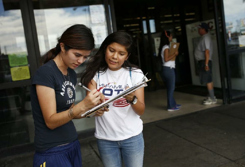 Fabiola Vejar (right) registers Stephanie Cardenas to vote in front of a Hispanic supermarket in Las Vegas in June.