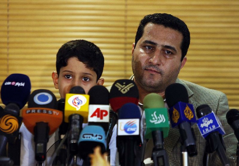 Shahram Amiri, an Iranian nuclear scientist, attends a news briefing with his son, Amir Hossein, as he arrives at the Imam Khomeini airport just outside Tehran, Iran, after returning from the United States in this file photo taken July 15, 2010.