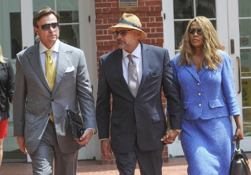 Tennessee Rep. Joe Armstrong (center), walking with his wife, LeTonia, and attorney Gregory Isaacs, leaves federal court in Knoxville on Monday after being convicted of tax fraud.