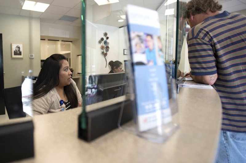 Patient coordinator Lizeth Guadalupe of Fayetteville speaks Monday with a client at the Community Clinic in Fayetteville. The Community Clinic served more than 35,200 people at its 14 locations last year.