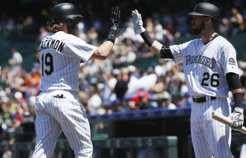 Colorado Rockies' Charlie Blackmon, left, is congratulated by David Dahl after hitting a solo home run off Texas Rangers starting pitcher A.J. Griffin in the first inning of a baseball game Tuesday, Aug. 9, 2016 in Denver. 