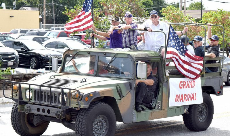 Grand marshal Clarence Amos, sitting in the passenger’s seat, leads the 2016 Decatur Barbecue Parade through downtown Decatur Aug. 6. Amos, along with his fellow veterans who were in the back, were honored in this year’s parade. The Lowell Police Department provided two Hummers which were filled with veterans from World War II, Korea, Vietnam and Desert Storm.