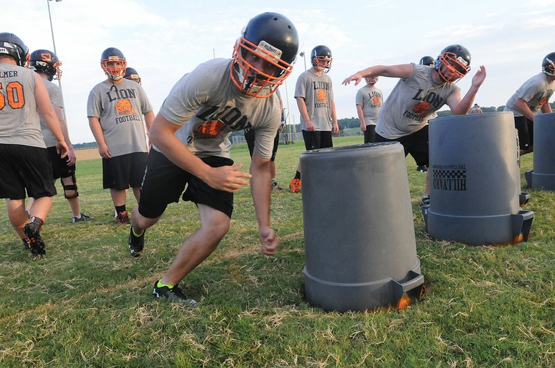 Gravette Lions high school football players run drills Tuesday during practice at Gravette High School.