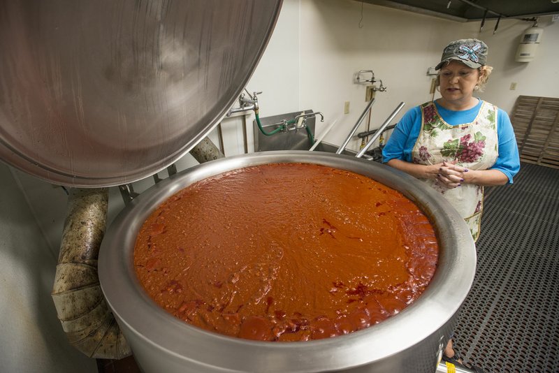 Silvia Pianalto Hall, volunteer with the Tontitown Grape Festival, shows the 90 gallons of spaghetti sauce Wednesday at the St. Joseph Parish Hall in Tontitown. The sauce will be served with the Tontitown Grape Festival spaghetti dinner, which starts tonight. Pianalto Hall will be the kitchen manager during the dinner.