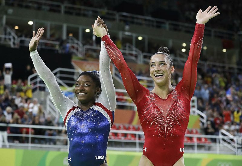 United States gymnasts Simone Biles (left) and Aly Raisman acknowledge the crowd after the duo became just the second pair of Americans to sweep the top two spots in the all-around competition Thursday at the Rio Games. Biles’ gold-medal victory adds to a dominating three-year run in which she won 14 world championship medals, including 10 golds. Raisman won the silver after missing out on a bronze at the 2012 Olympics because of a tiebreaker.