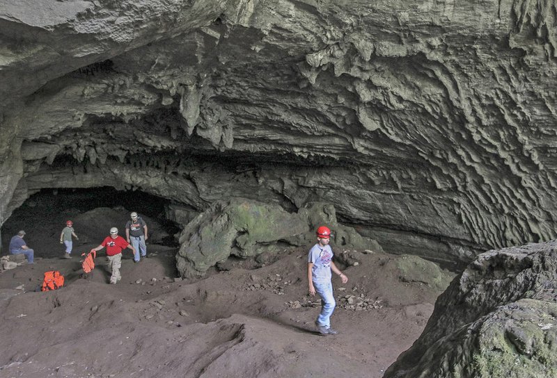 Firefighters from Izard and Independence counties exit the mouth of Blowing Cave in Cushman on Thursday afternoon after searching for three Arkansas State University students who had disappeared while on a spelunking trip in the area. 