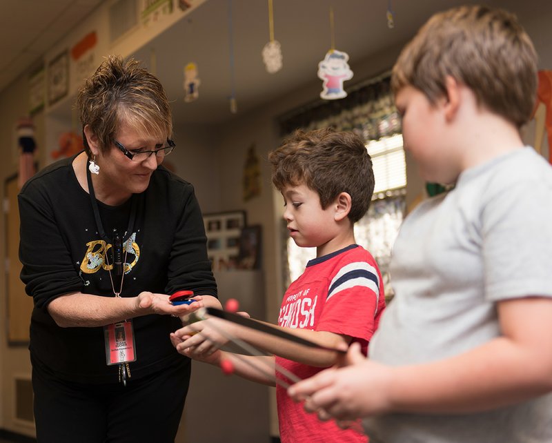 From left, Susan Bucher, McRae Elementary School music teacher, shows second-graders Tripp Bean and Jacob Almond instruments. Bucher, Searcy Public School’s 2016-2017 Teacher of the Year, has been named a regional finalist in the Arkansas Teacher of the Year contest. 