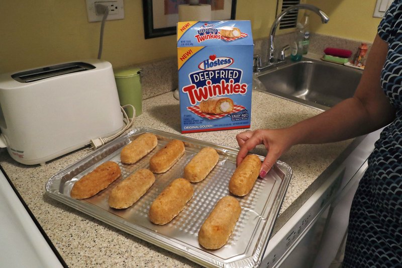 Associated Press reporter Anne D'Innocenzio arranges frozen, deep-fried Twinkies on a tray before baking in New York. The deep-fried Twinkie is jumping from the state fair to an oven near you. Hostess is launching packaged “Deep Fried Twinkies” that mark its first foray into frozen foods.
