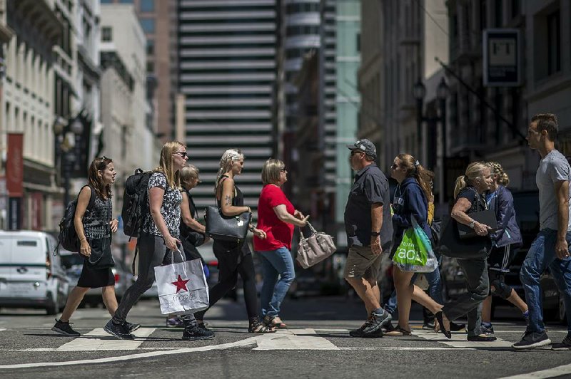 Shoppers cross Post Street in San Francisco on Wednesday. A 6 percent plunge in profi t margins at clothing and jewelry stores last month was the biggest since such records began in 2009.