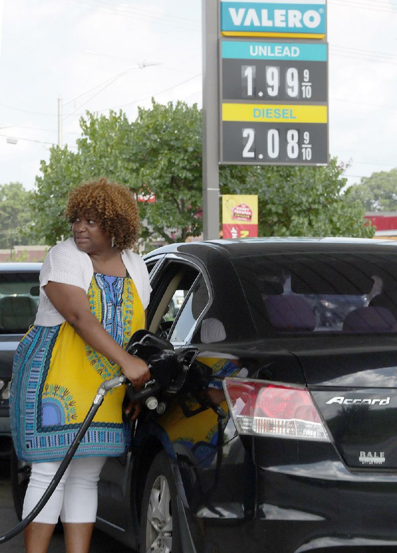 Teresa Hourston pumps gas Friday at a Valero station in North Little Rock. With gasoline averaging $1.94 a gallon, Arkansas is one of 11 states with prices below $2.
