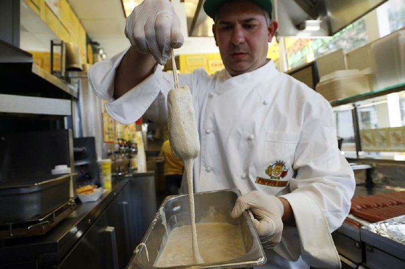 Wayne Rosenbaum, president of the hot-dog chain Papaya King, dips a Twinkie in batter before frying it at a store in New York.
