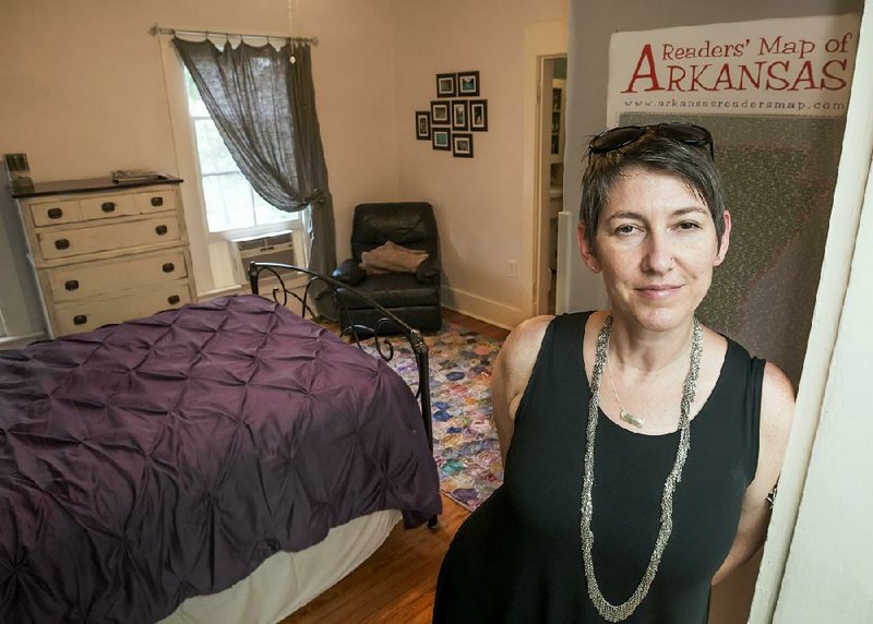 Stephanie Harris stands in the doorway of a room in her historic home in downtown Little Rock that she and her husband rent out through Airbnb.