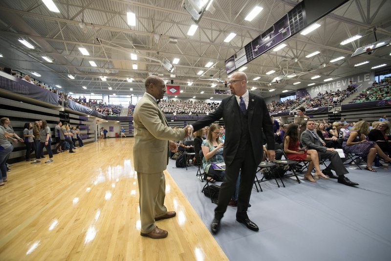 Fayetteville Superintendent Matthew Wendt (right) speaks Friday with Assistant Superintendent John L. Colbert during the conference for School District employees in Fayetteville High School’s gymnasium.