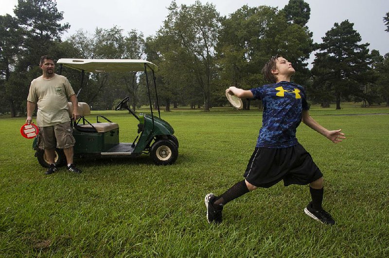 Logan Tatum, 12, tosses a disc while his dad waits his turn at Pine Valley Golf Course. Pine Valley built foot golf and disc golf courses in the past 1½ years, in addition to regular golf. 