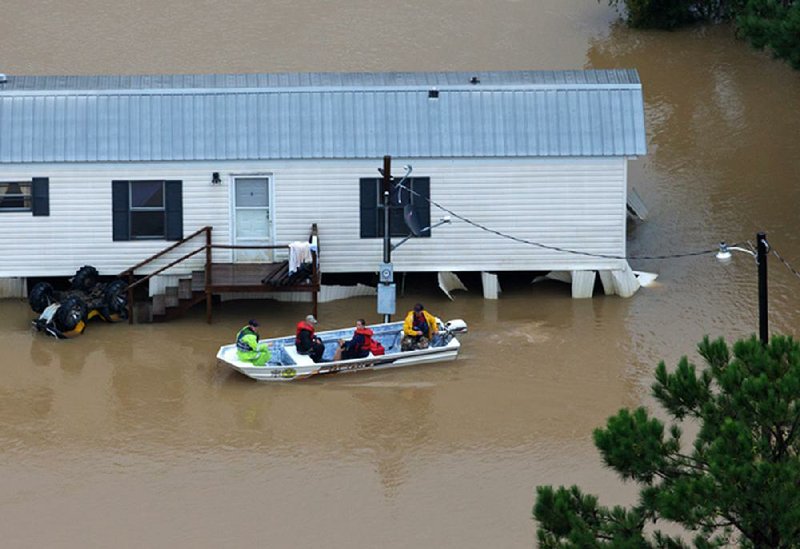 Rescuers ferry people from their home Saturday near the flooded Tangipahoa River in southeastern Louisiana. “This is an ongoing event. We’re still in response mode,” Gov. John Bel Edwards said.