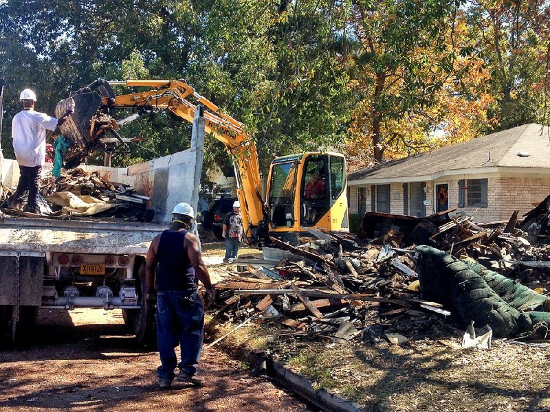 Parolees working under Arkansas Community Correction tear down a condemned house on 19th Street in Pine Bluff in October 2015 as part of a pilot program.