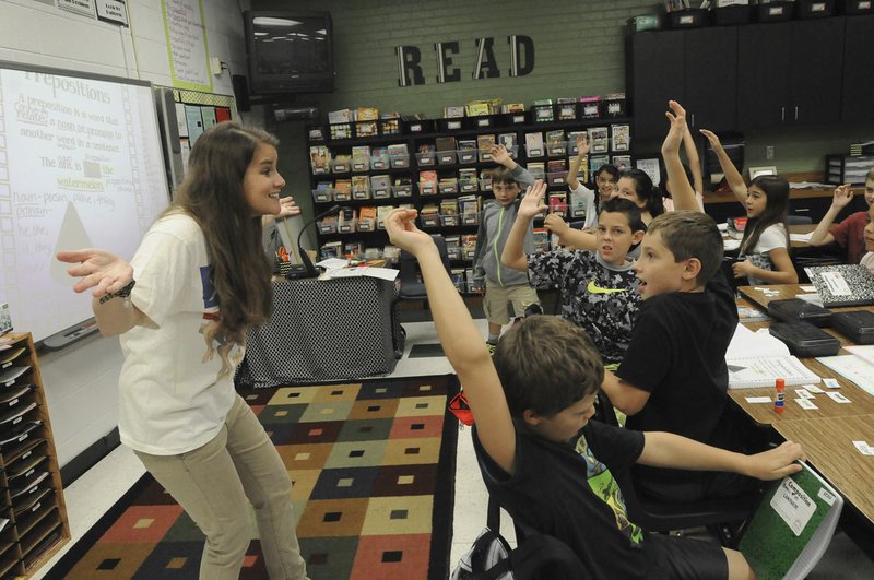 Rachel Watterson, fifth-grade teacher at Eastside Elementary School in Rogers, works with students Wednesday in her classroom.