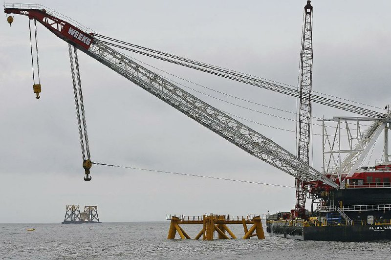In a 2015 photo, a construction crane works over a foundation installed for a wind farm Deepwater Wind is building off the coast of Block Island, R.I.
