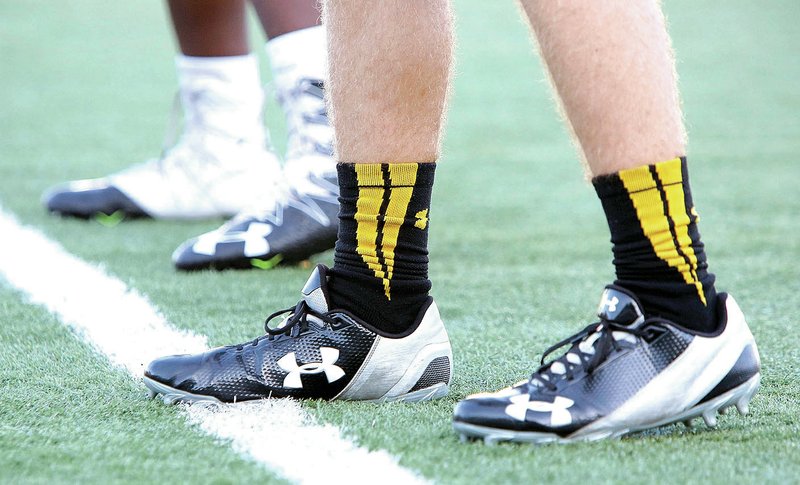 Under Armour cleats are worn by Fayetteville High School football players during practice Aug. 1 at Harmon Stadium in Fayetteville.