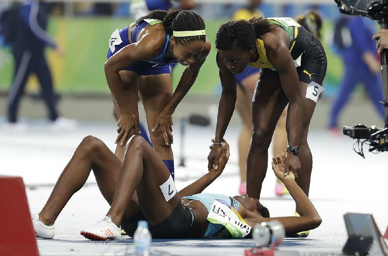 United States sprinter Allyson Felix (left) and Jamaica’s Shericka Jackson (right) speak to Shaunae Miller of the Bahamas after Miller dove across the goal line to win the women’s 400-meter fi nal Monday by .07 seconds at Olympic Stadium in Rio de Janeiro. Felix finished second, followed by Jackson.