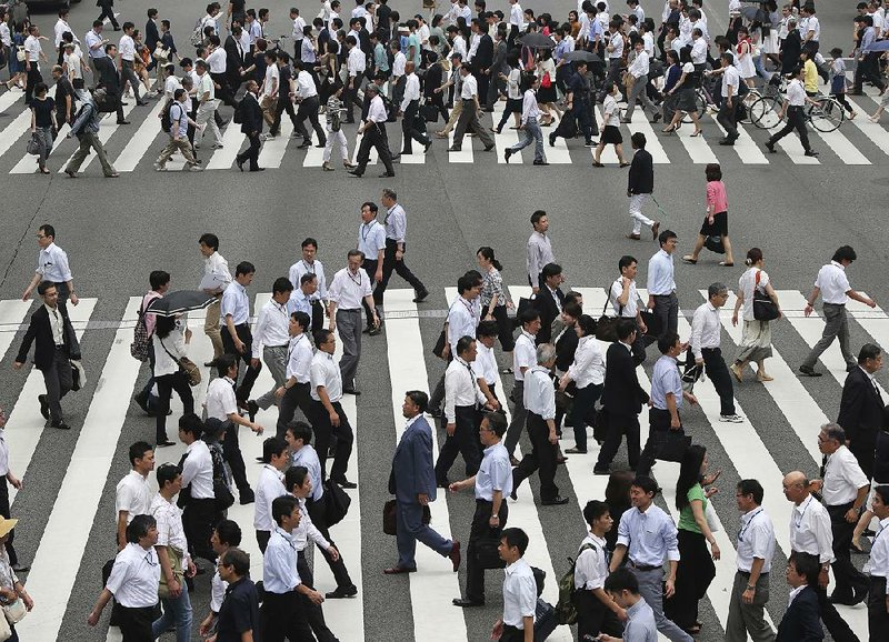 Pedestrians cross a street in Tokyo in this July 1 file photo. Japan’s economy expanded at a 0.2 percent annual pace in the last quarter, the government said Monday.
