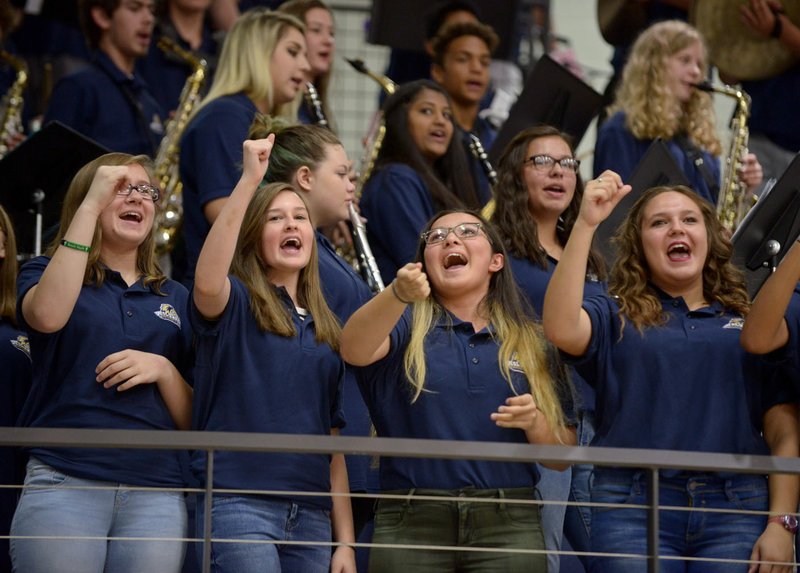 Members of the West High School band chant Monday as they play the school’s fight song during an assembly on the first day of school in Centerton.