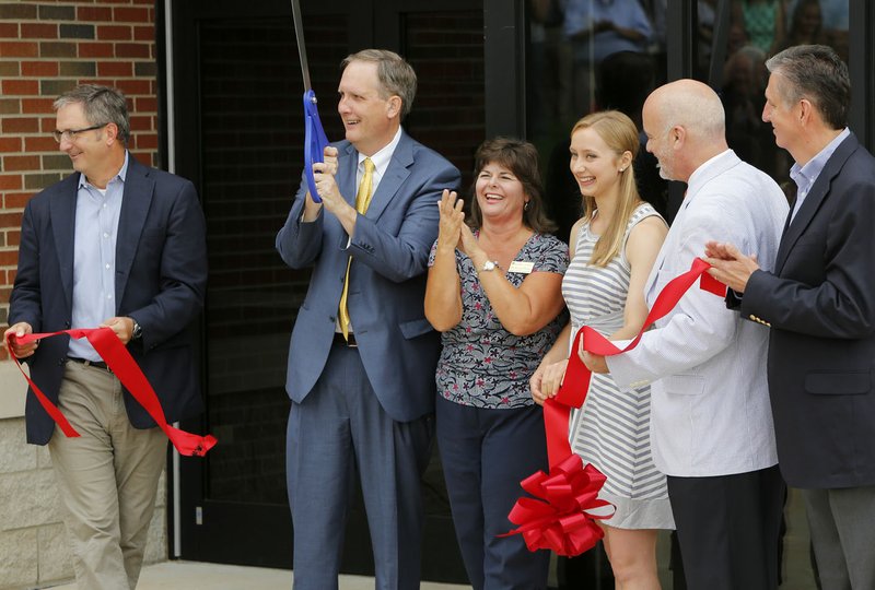 Steve Beers (from left), vice president for student development at John Brown University, Chip Pollard, president, Ellen Odell, director of nursing, Anna Klein, a junior and first year nursing student, Jeff Terrell, dean of College of Education and Human Services, and Jim Krall, vice president for University Advancement, cut the the ribbon Monday, August 15, 2016, during opening ceremonies for the new Health Education Building on the campus in Siloam Springs. The University is enrolling its first nursing students this fall.