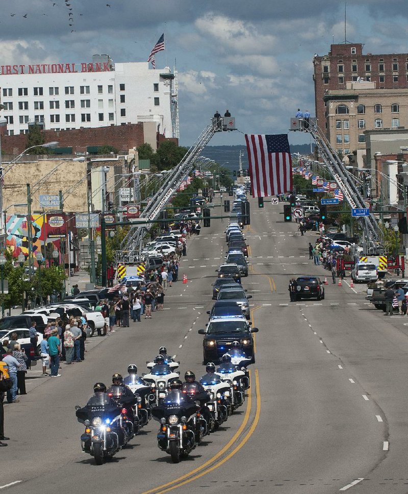 The funeral procession for Cpl. Bill Cooper moves along Garrison Avenue in Fort Smith after the funeral service for the Sebastian County sheriff’s deputy at the Fort Smith Convention Center. About 2,500 people attended Cooper’s funeral service, and it took more than an hour for the procession to pass. 